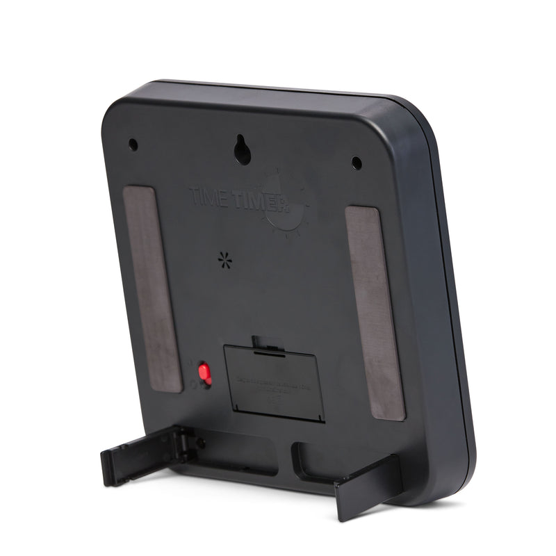 The back of the Time Timer® Original 8” 60-minute visual timer is shown. It showcases two large magnets that can be used to display the timer on a magnetic surface. It is shown propped up on the built-in foldable feet for an easy display on a tabletop. 